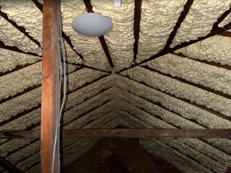 Spray foam insulation between attic rafters for energy efficiency