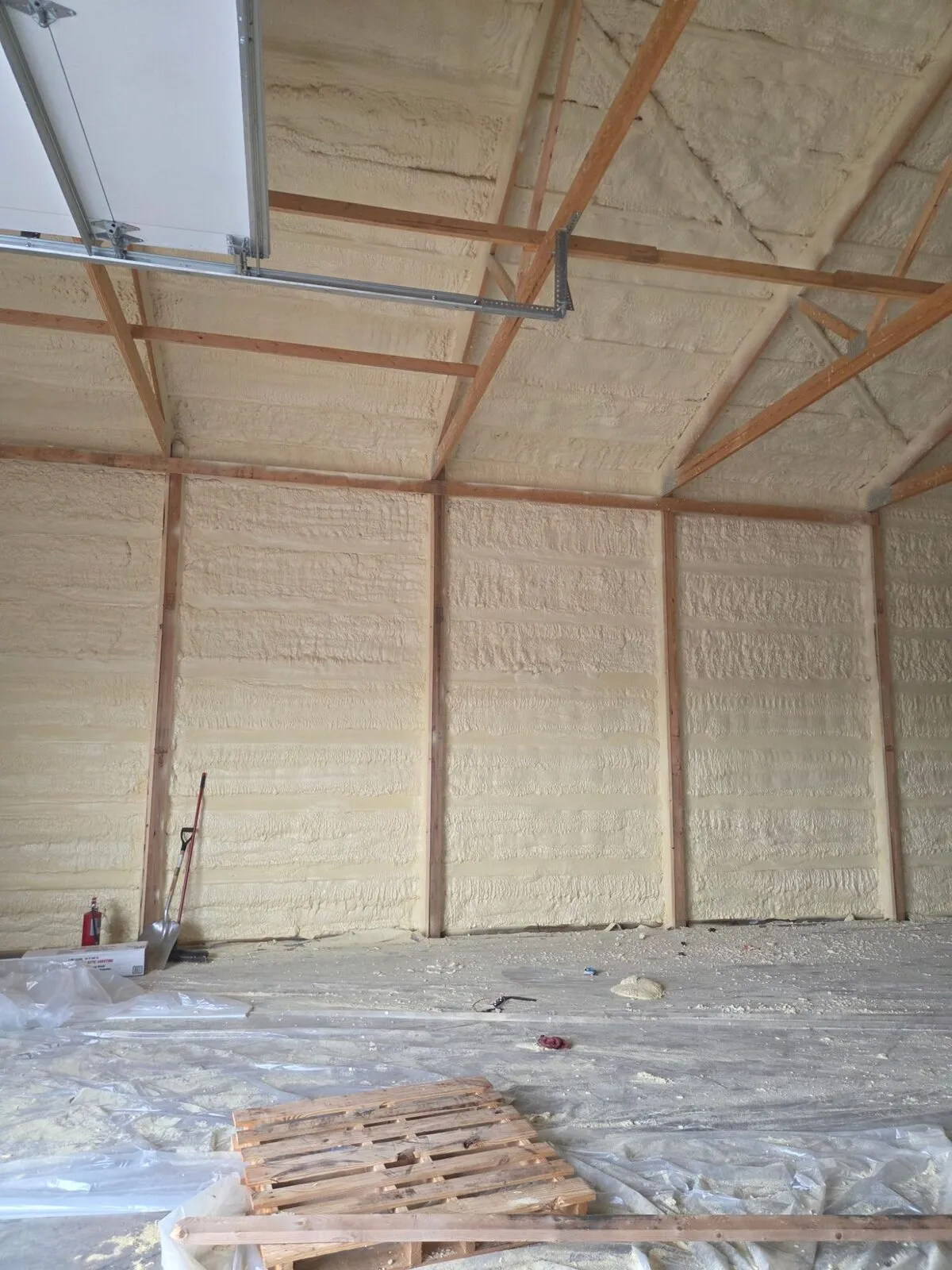 Spray foam insulation on garage walls and ceiling around the overhead door track